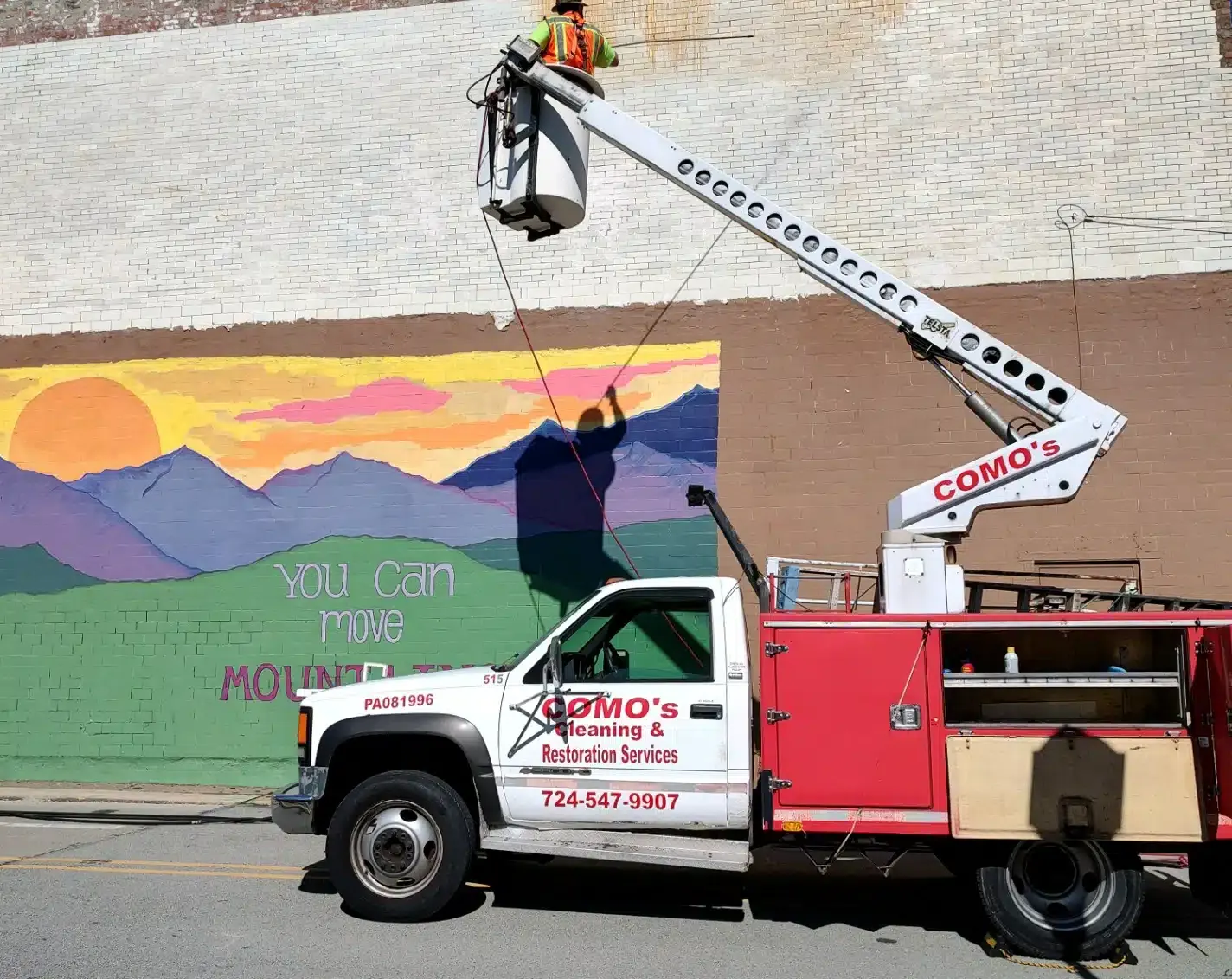 Truck with lift painting a mural