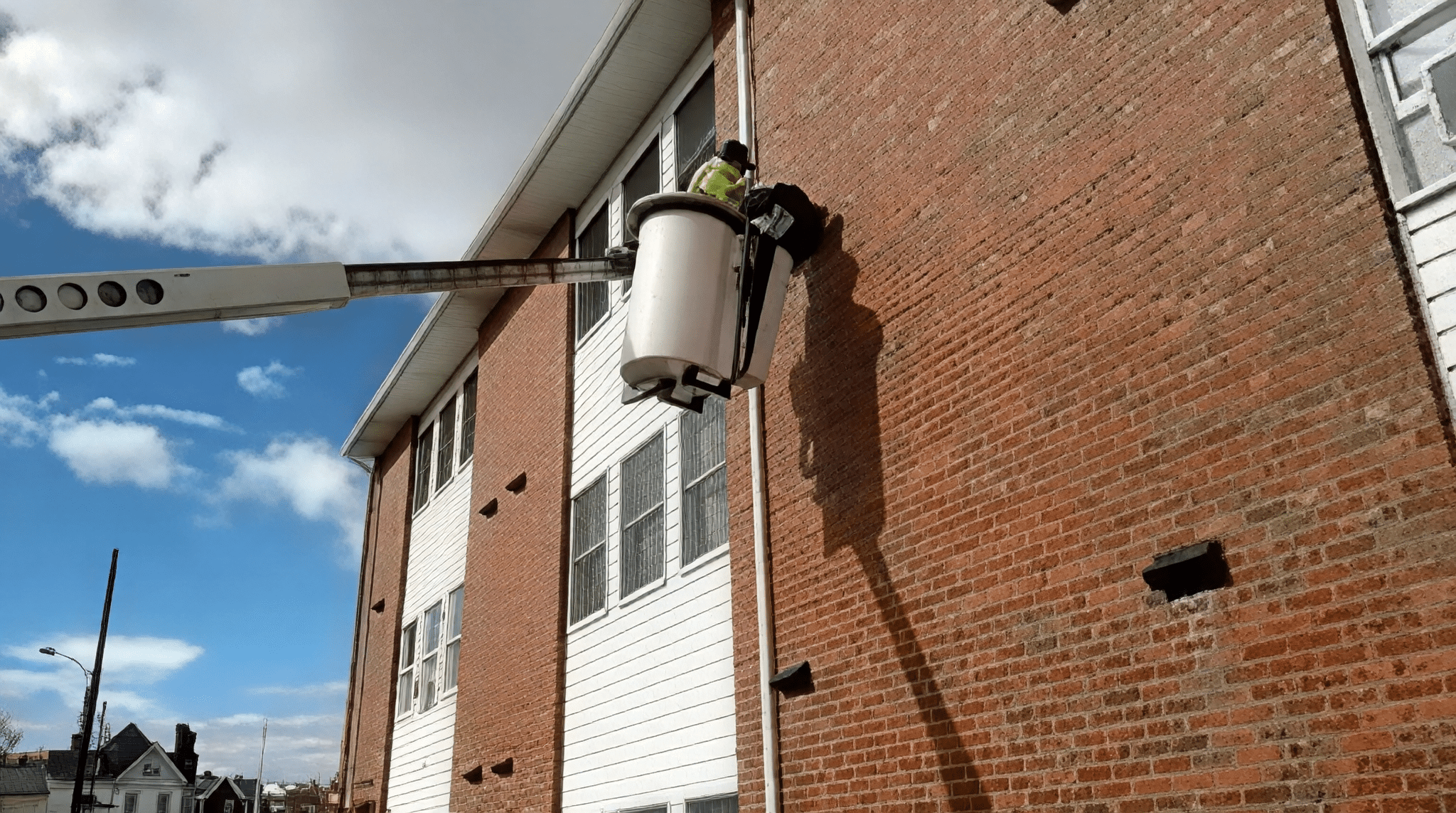 Person in cherry picker near windows