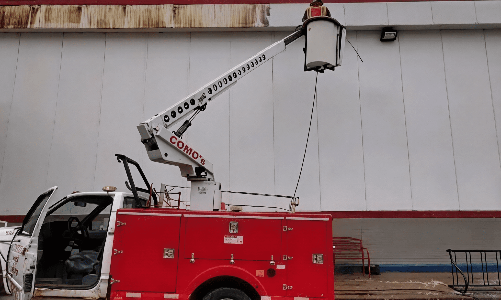 Red utility truck with elevated bucket