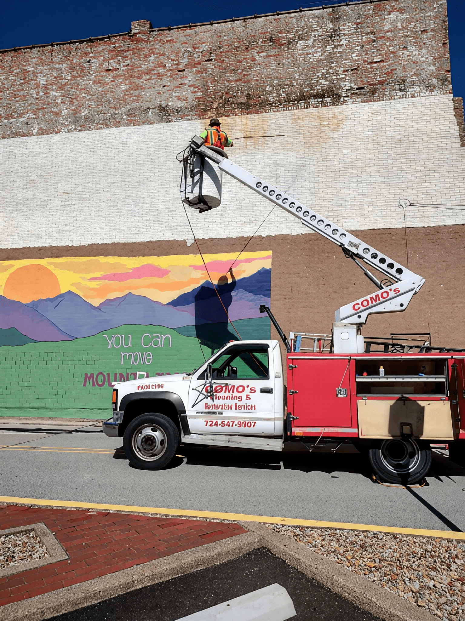 Artist painting colorful mural on wall