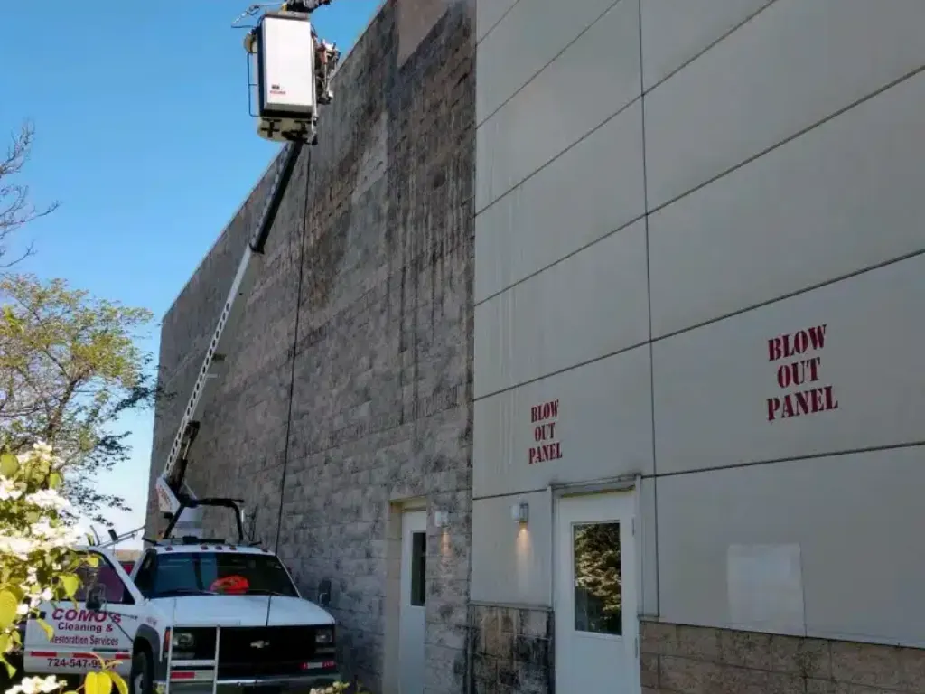Worker on lift inspecting building facade